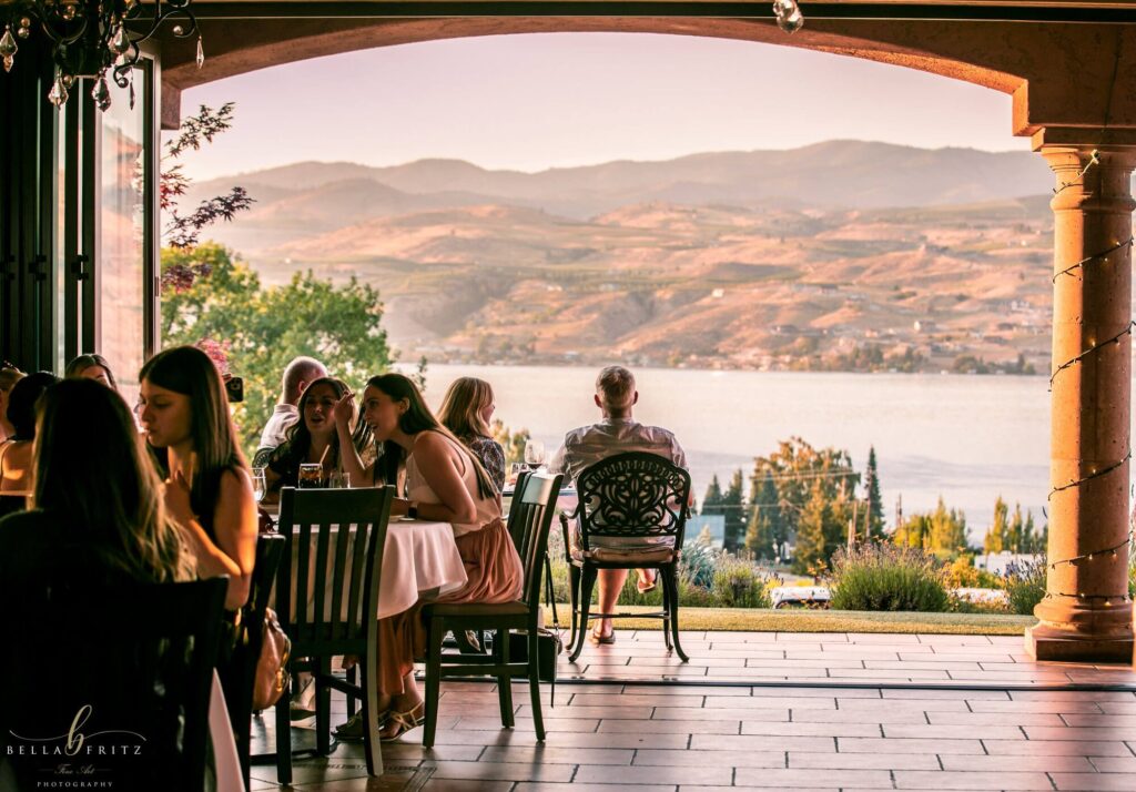 Guests dining under the arches with a view of the lake