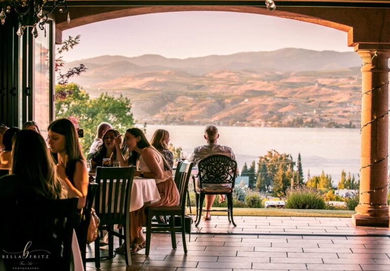 Guests dining under the arches with a view of the lake